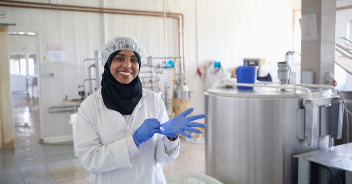 A woman with gloves in manufacturing site
